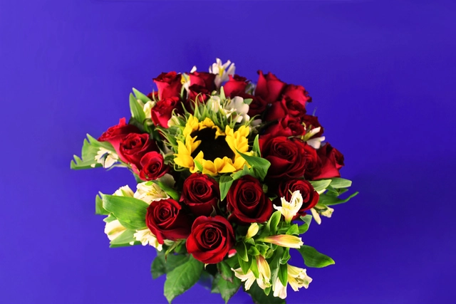 Jarrón de vidrio con 24 Rosas rojas y un Girasol